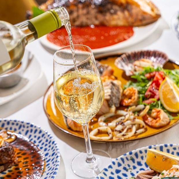 White wine poured beside a seafood spread